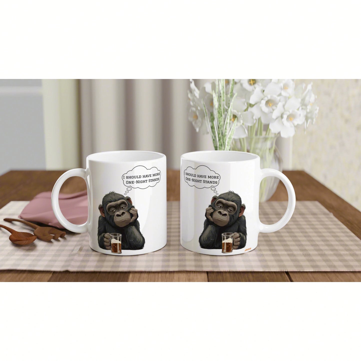 Two white mugs on a wooden table feature a cartoon chimp holding a drink with a speech bubble; product mockup.