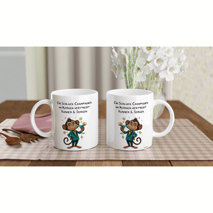Two white mugs feature a cartoon monkey in a teal suit toasting champagne, set on a wooden table.
