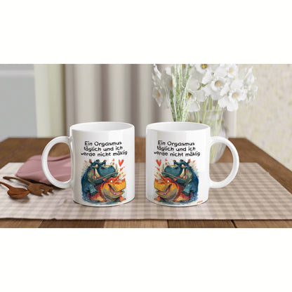 Two white mugs on a wooden table with a colorful dragon illustration and a German humorous slogan.