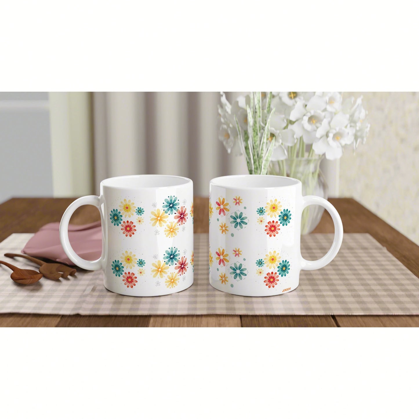 Two white ceramic mugs with colorful flower patterns on a wooden table.