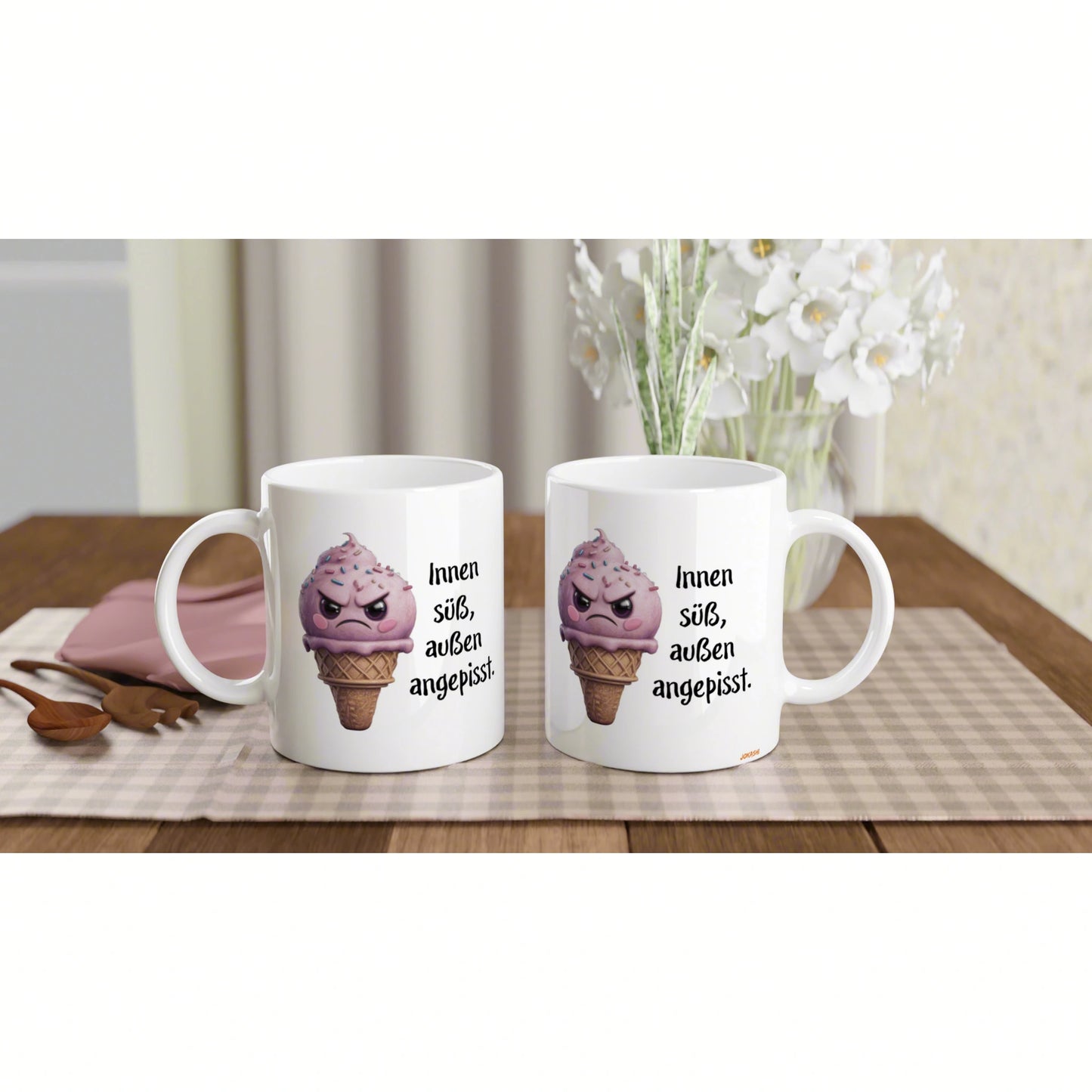 Two white mugs featuring a pink ice-cream cone cartoon and the German phrase Innen süß, außen angepisst.