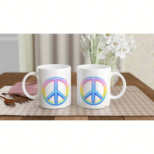Two white mugs with rainbow peace symbols sit side-by-side on a beige checkered placemat on a wooden table.