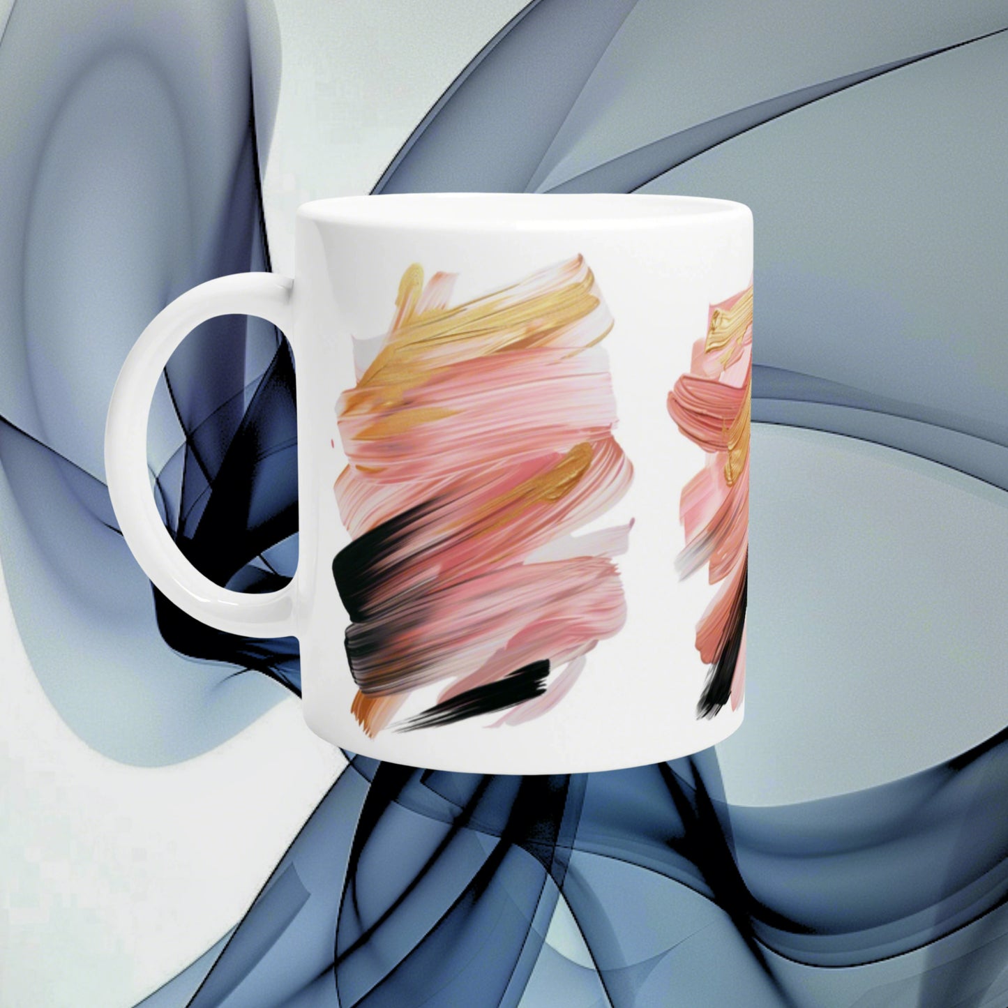 White ceramic mug with an abstract brush-stroke design in pink, peach and black; product mockup.