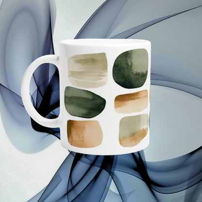 White ceramic mug with abstract brushstroke patches in beige, olive green and brown; product mockup.