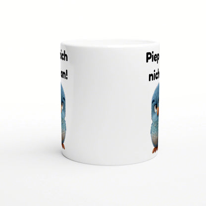 White ceramic mug mockup with blue cartoon birds peeking from the sides and partial black text around the rim.
