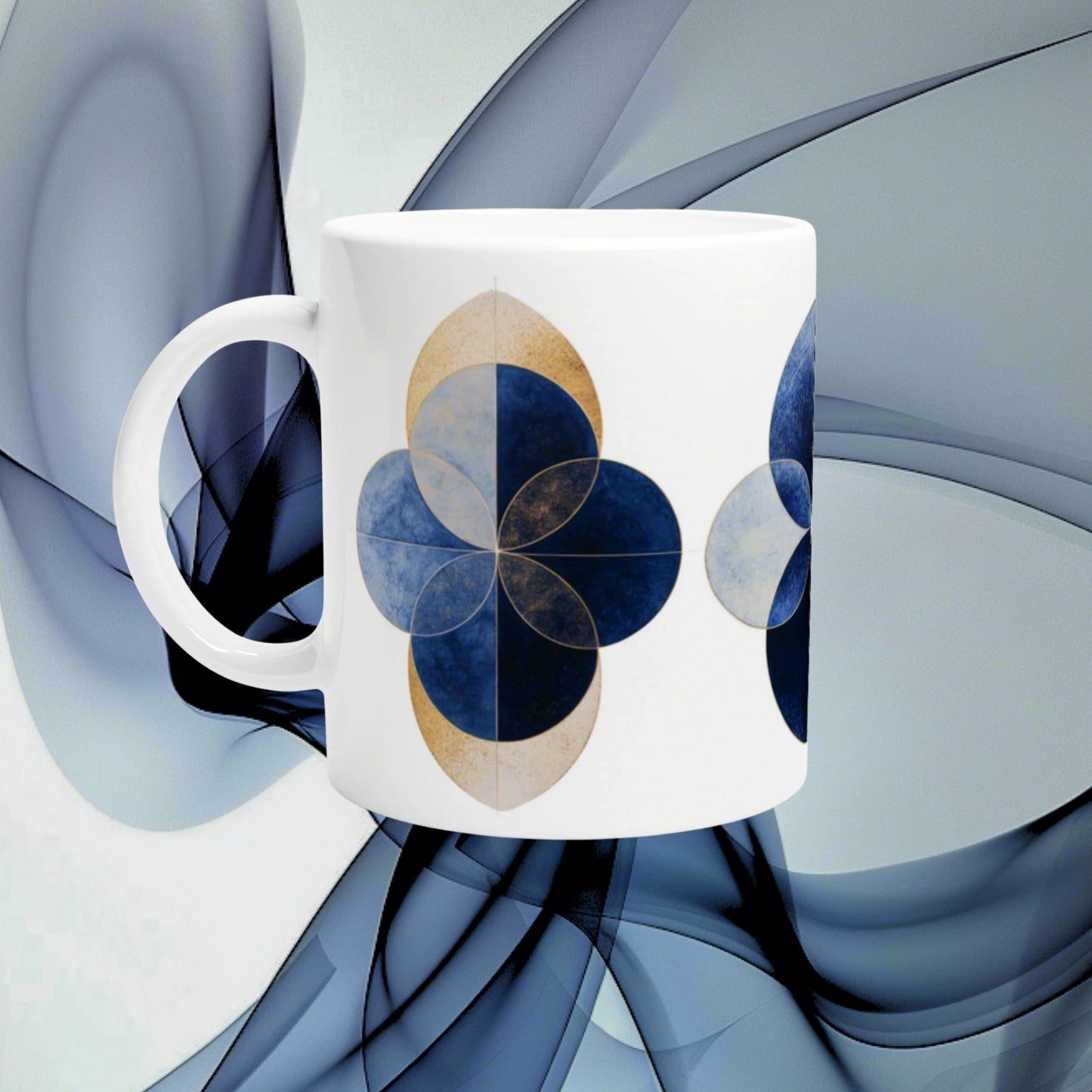 White ceramic mug with blue geometric four-leaf clover motifs against an abstract blue background.