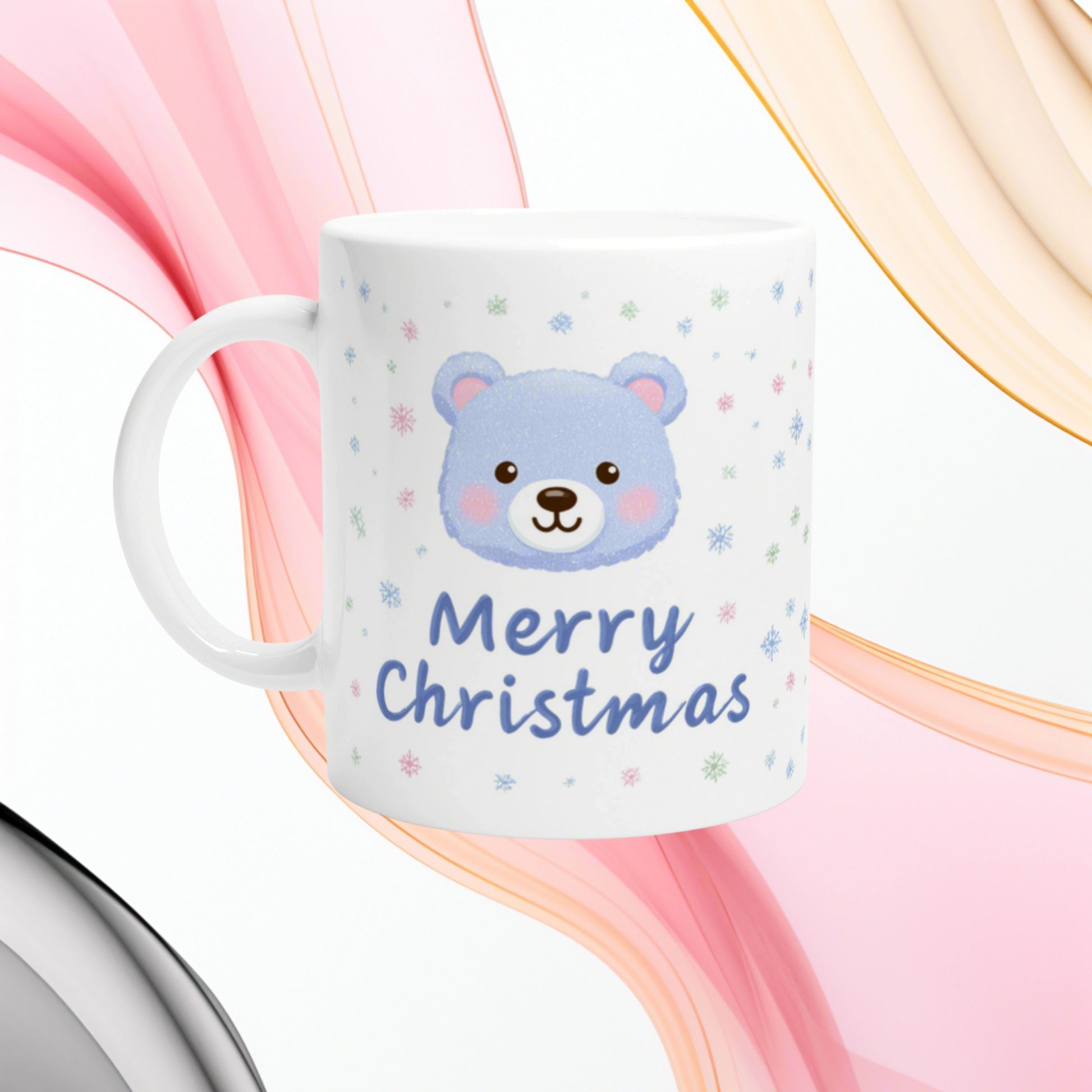 White ceramic mug featuring a blue teddy bear face and 'Merry Christmas' text with pastel snowflakes; product mockup.