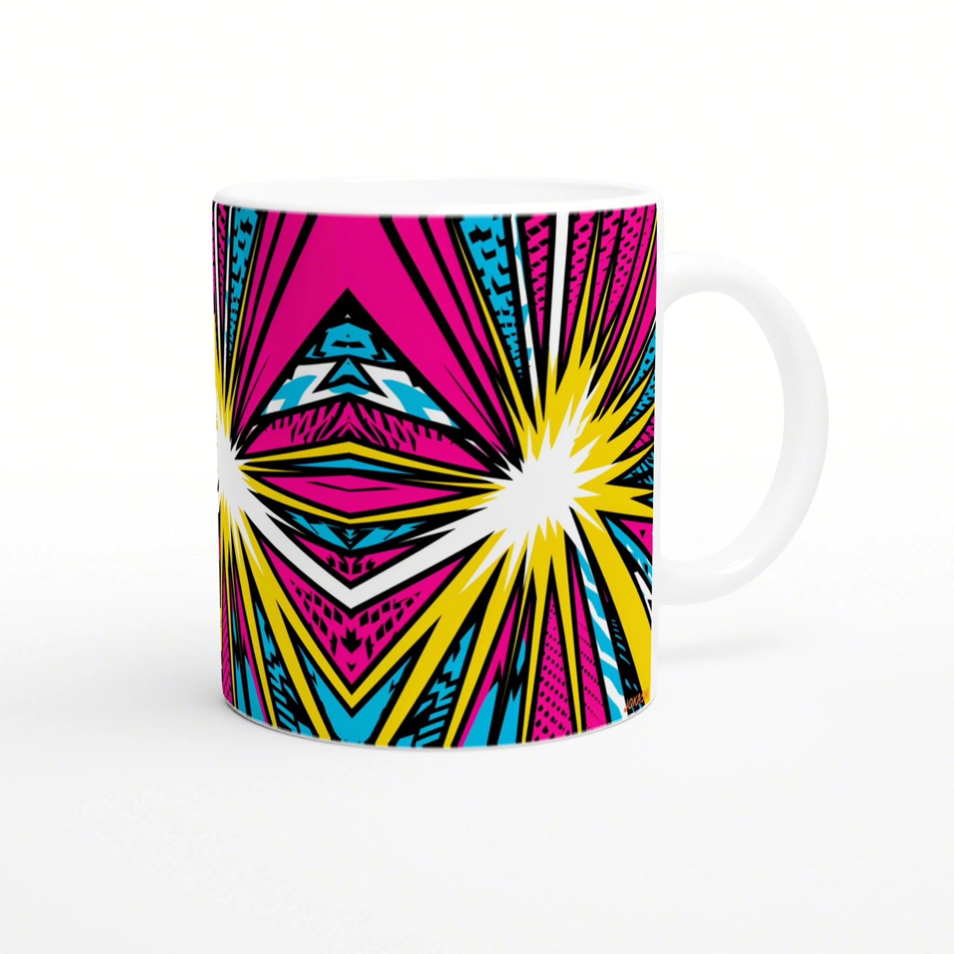 White ceramic mug with bold pop-art pattern in pink, yellow, cyan and black; geometric starbursts across the surface.
