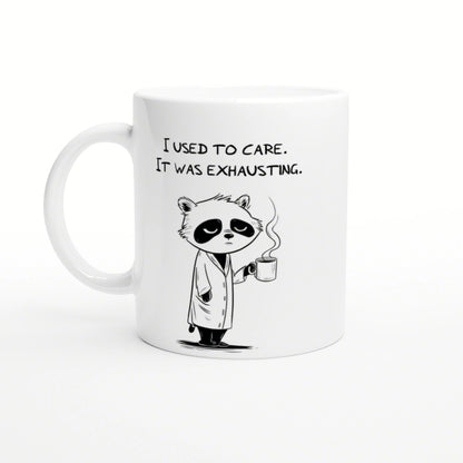 White ceramic mug with a cartoon panda in a robe, holding a steaming mug and the caption 'I used to care. It was exhausting.'