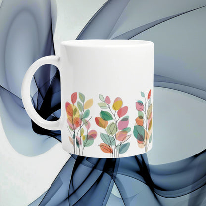 White ceramic mug featuring a colorful leafy floral pattern around the base; product mockup on abstract blue background.