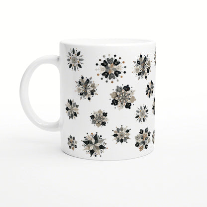 White ceramic mug featuring scattered black, beige and gray floral snowflake patterns; product mockup.
