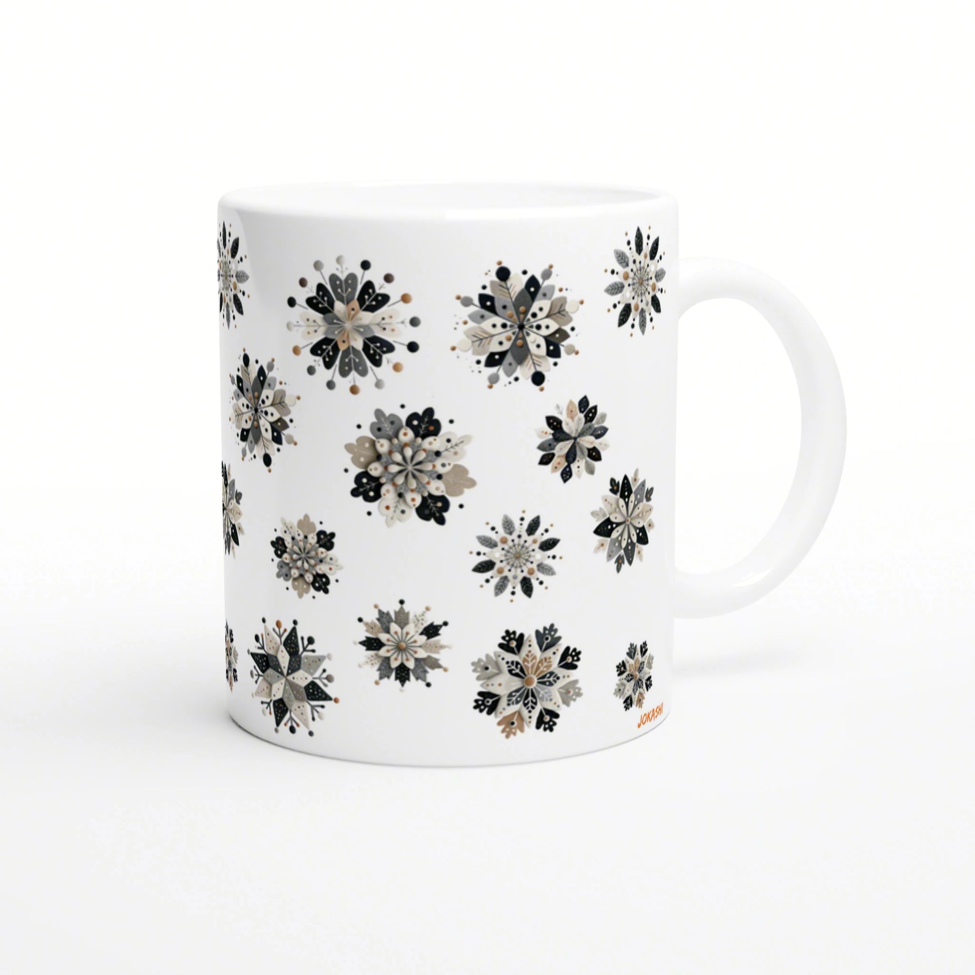 White ceramic mug with a repeating pattern of beige, black, and gray floral snowflake clusters; product mockup.