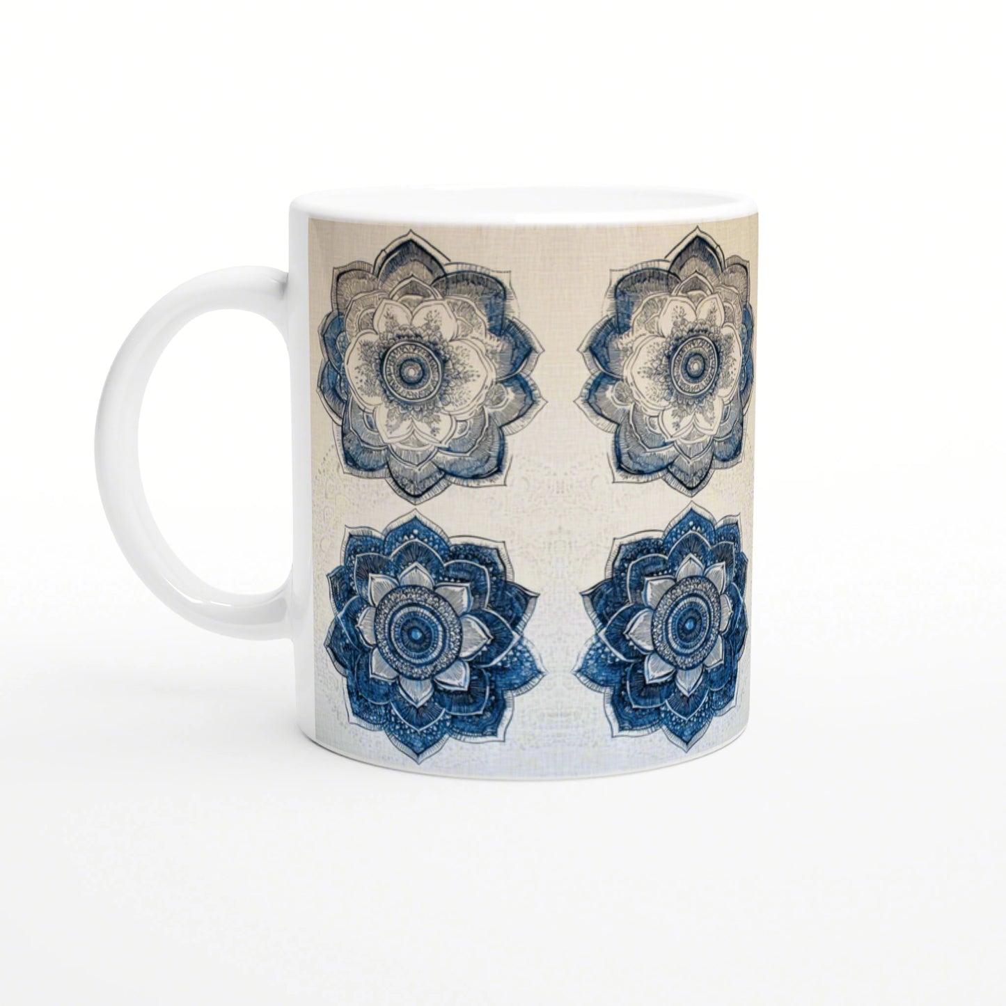 White ceramic mug with four blue mandala flowers on a beige textured background; product mockup.