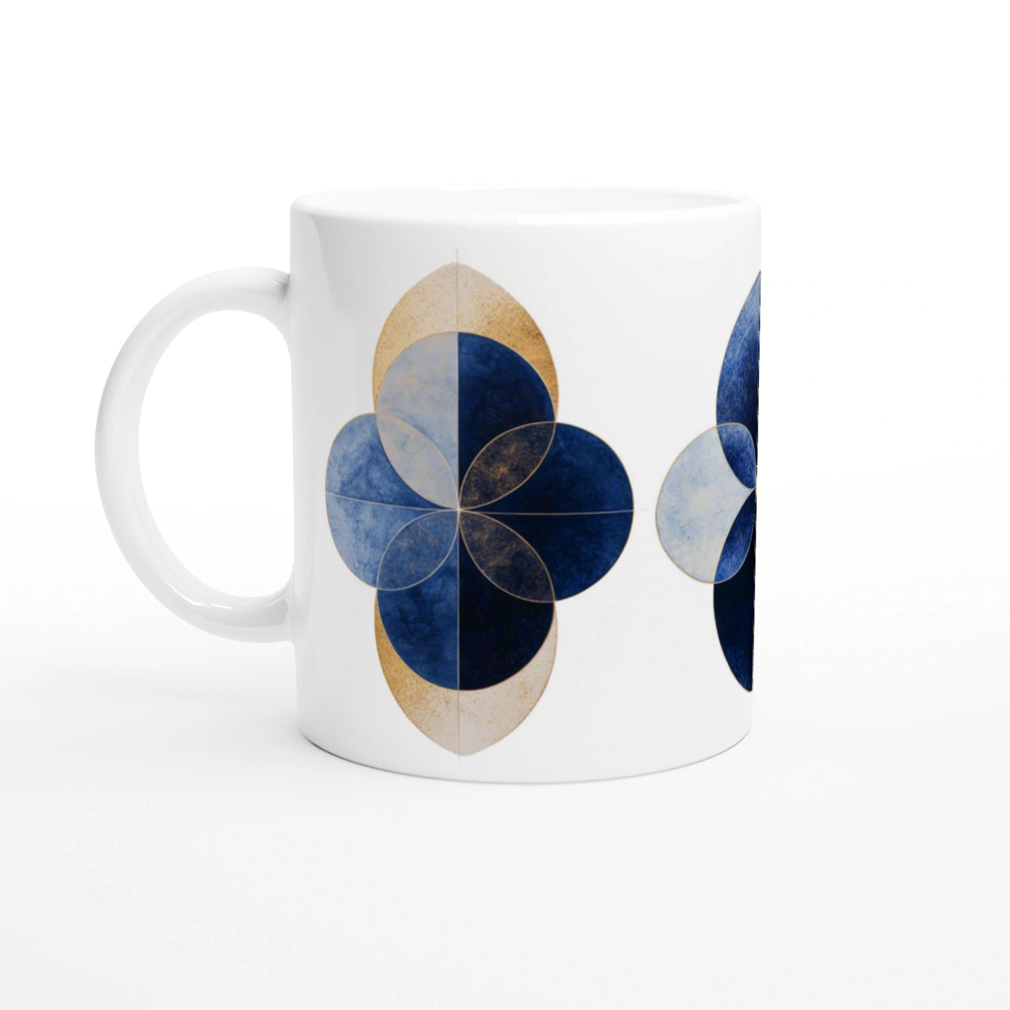 White ceramic mug with a geometric blue floral motif and gold outlines; four overlapping blue petals.