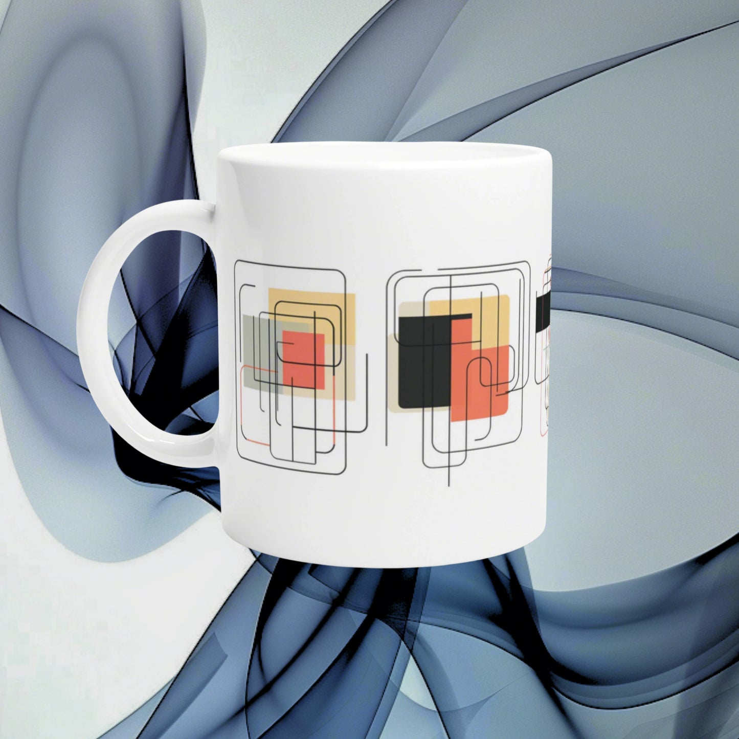 White ceramic mug with overlapping geometric square patterns in red, black, and beige against a blue abstract background.