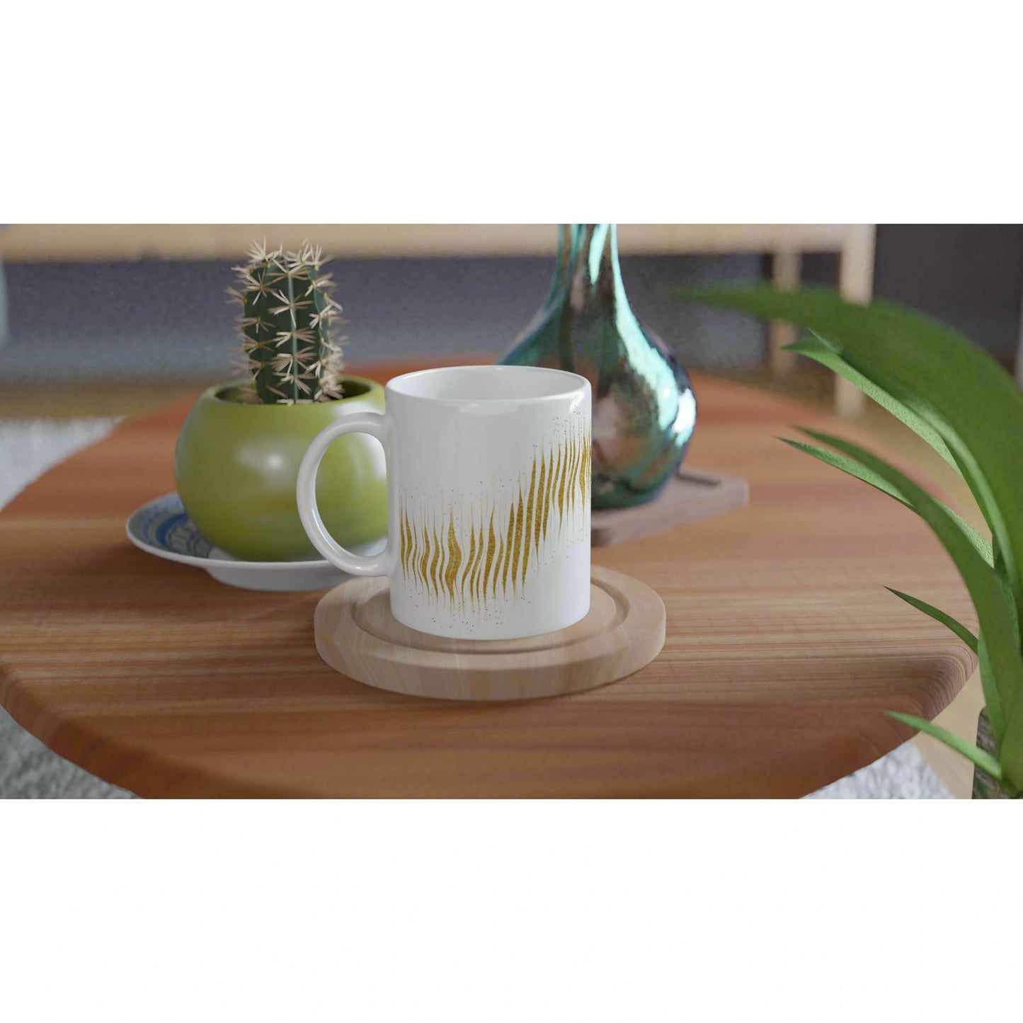 Product mockup: white ceramic mug with gold wavy pattern on a wooden coaster, beside a cactus pot and turquoise vase.