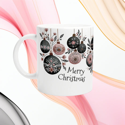 White ceramic mug featuring hanging Christmas ornaments in black and pink with the text Merry Christmas.