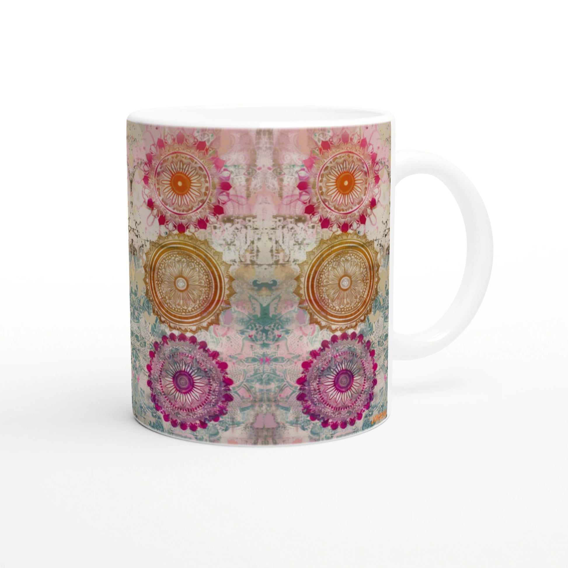 White ceramic mug with a wraparound kaleidoscopic mandala pattern in pink, orange, teal and purple.