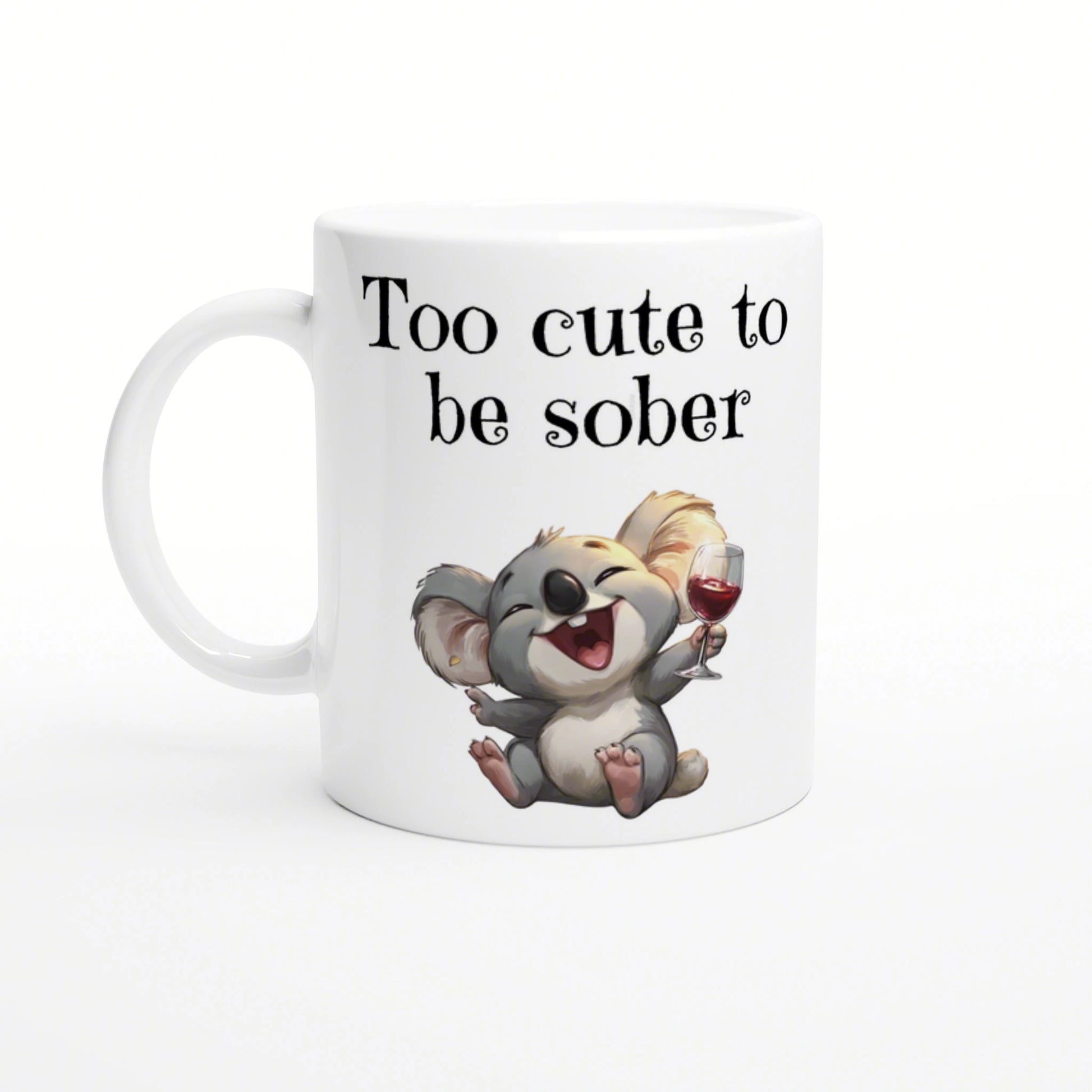 White ceramic mug featuring a joyful cartoon koala holding a wine glass with the slogan Too cute to be sober.
