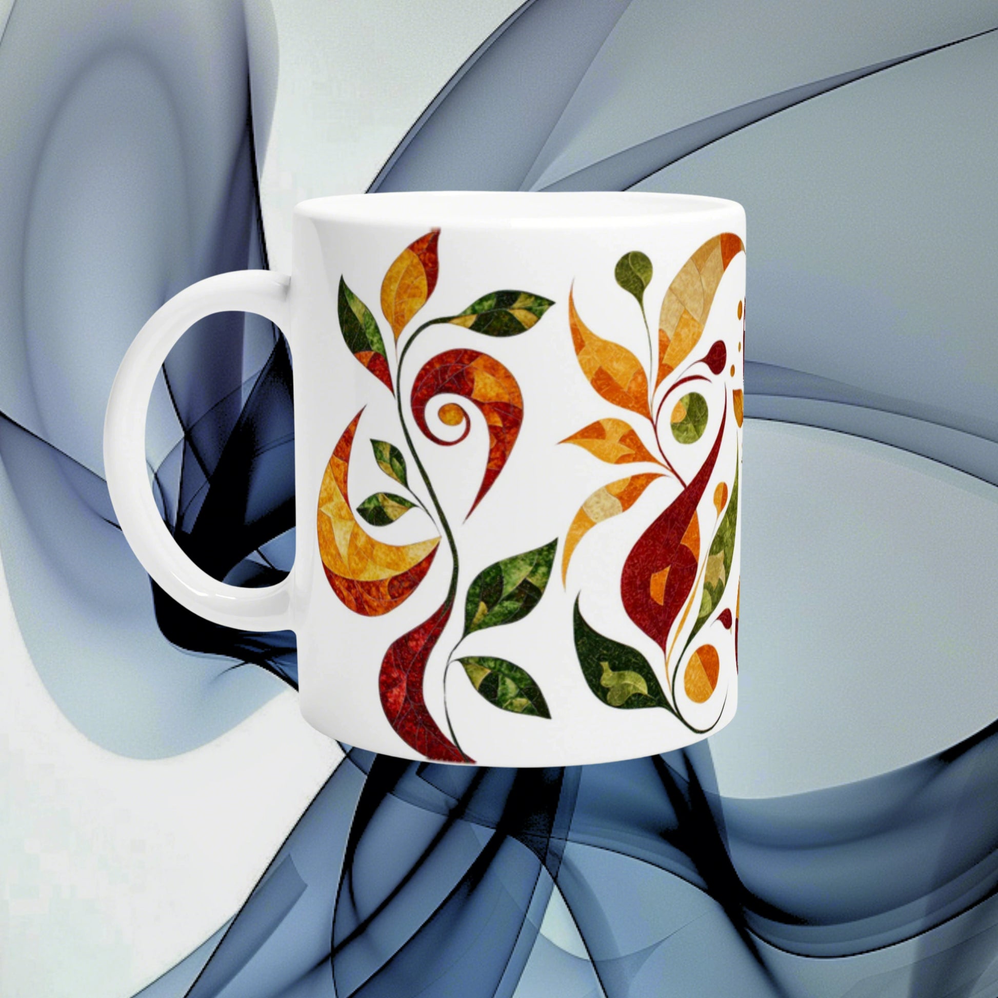 White ceramic mug mockup with a colorful abstract leaf pattern in orange, red and green on a blue abstract background.