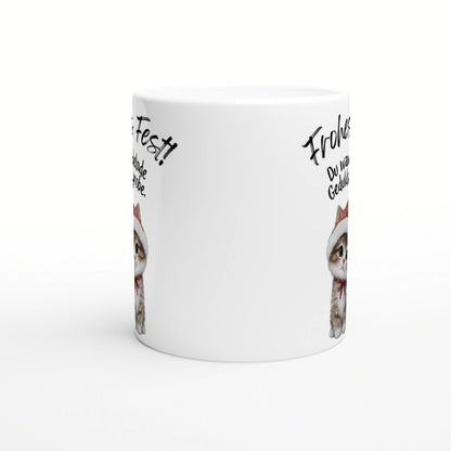 White ceramic mug mockup featuring a cute kitten wearing a Santa hat with handwritten German phrases around the rim.