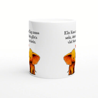 White ceramic mug mockup with black German text circling the sides and small orange cartoon elephants near the bottom.