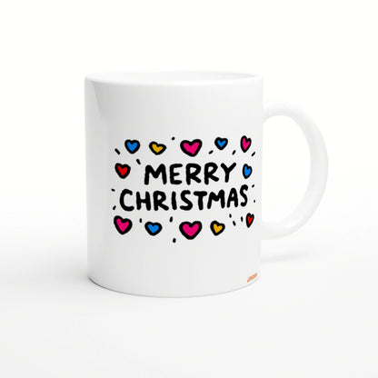 White ceramic mug mockup featuring a hand-drawn 'MERRY CHRISTMAS' design with colorful hearts and doodle accents.