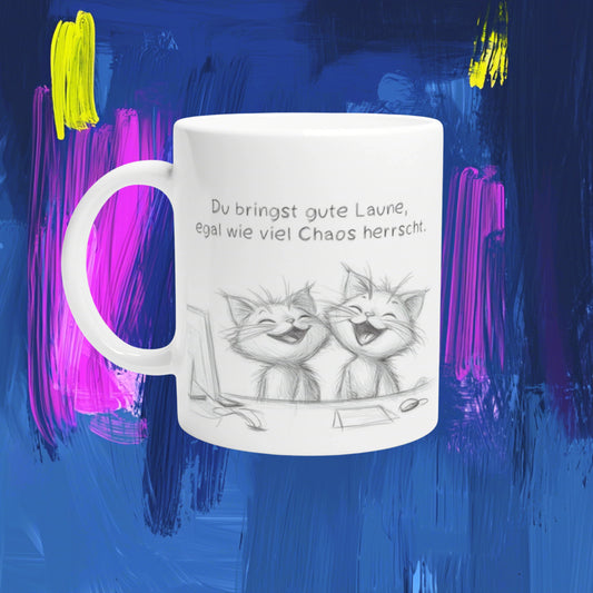 White ceramic mug mockup showing two laughing cats in a pencil sketch and a German slogan about good mood amid chaos