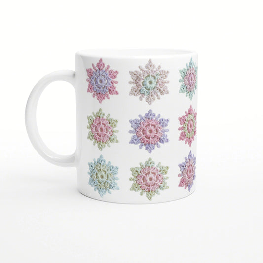 White ceramic mug with a repeating pattern of pastel crochet-style flowers.