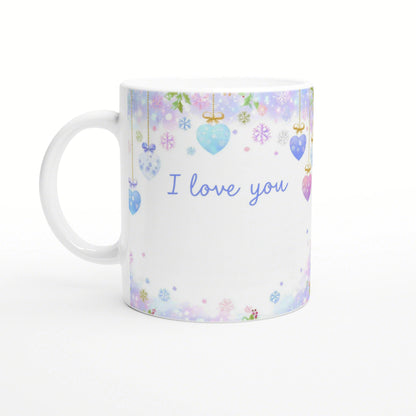 White ceramic mug with pastel hanging hearts and snowflakes and blue 'I love you' text; product mockup.