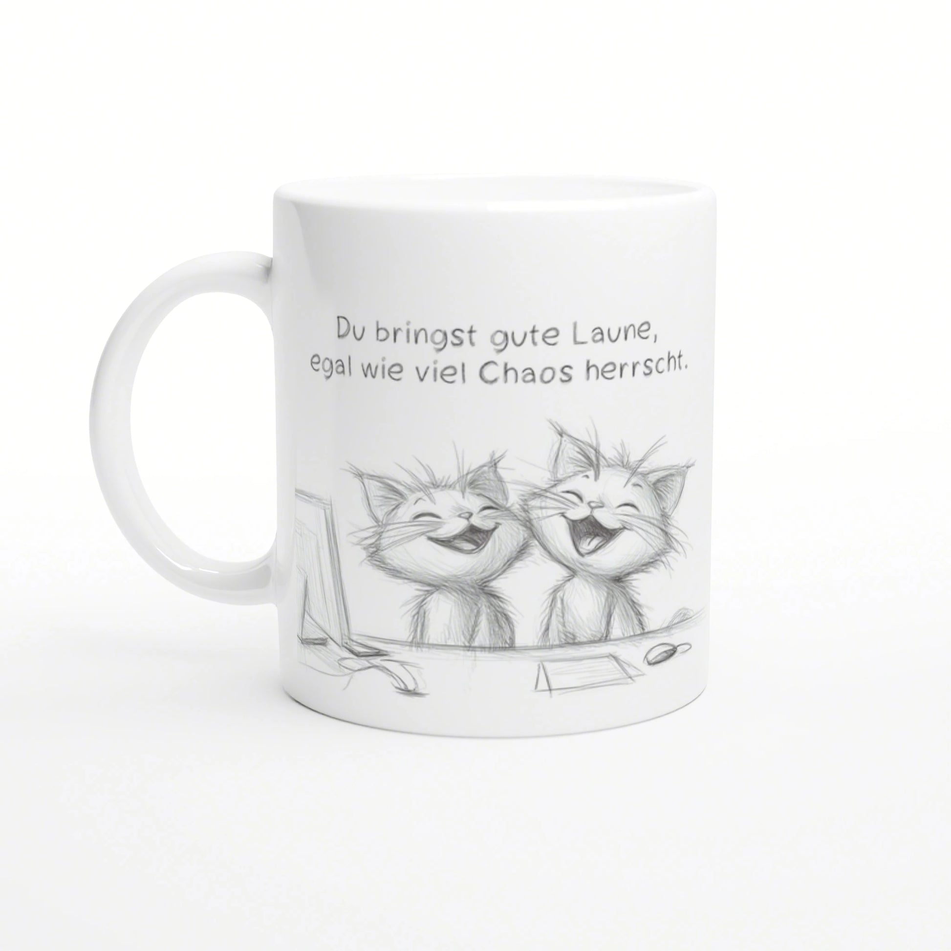 White ceramic mug featuring a pencil sketch of two laughing cats and a German caption about good mood despite chaos.