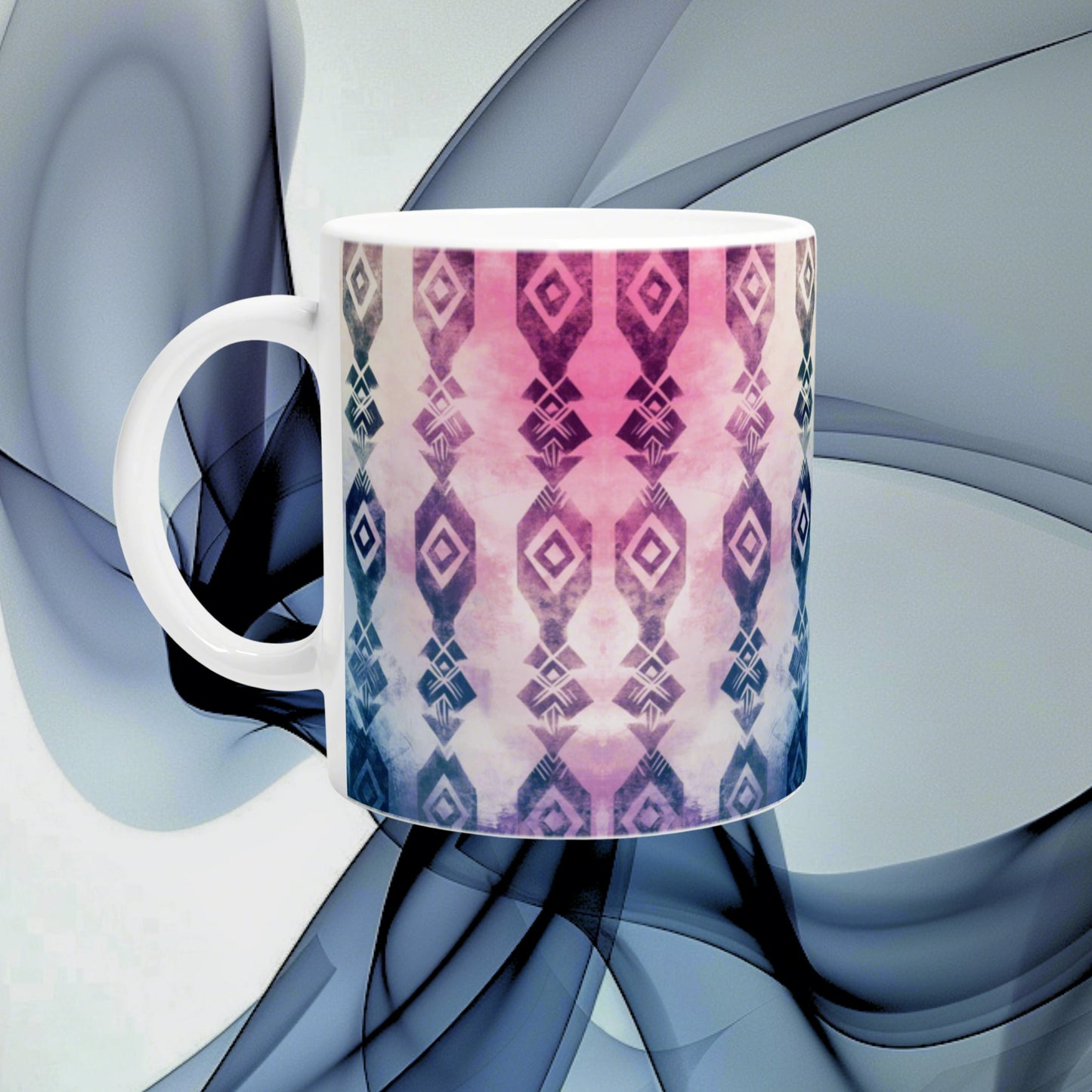 White ceramic mug with pink-to-blue geometric diamond pattern, shown as a product mockup against an abstract blue backdrop.
