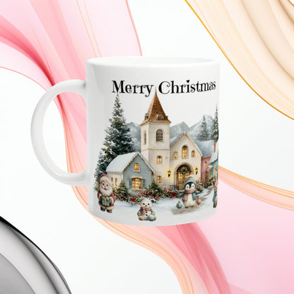 White ceramic mug featuring a snowy Christmas village with a church, houses and the words Merry Christmas.
