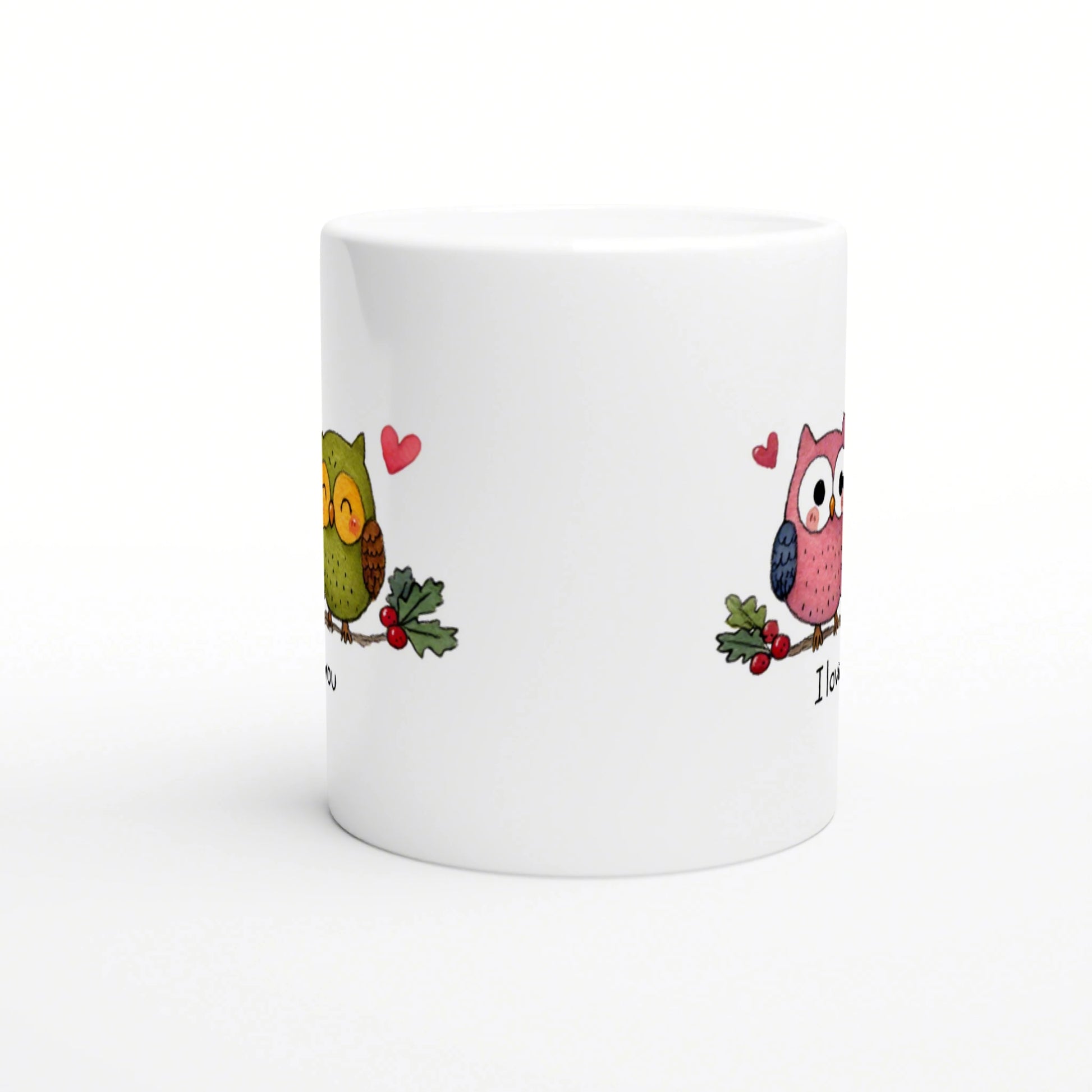 White ceramic mug featuring two cartoon owls with hearts and holly on the sides; playful product mockup.