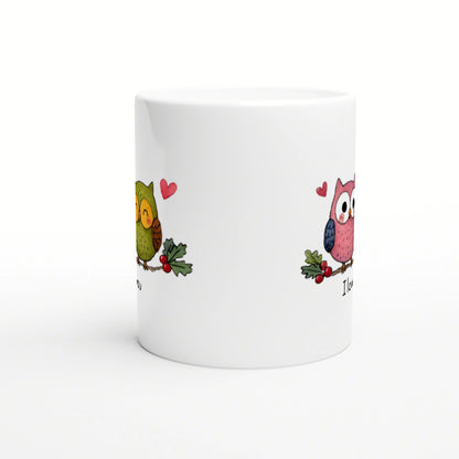White ceramic mug featuring two cartoon owls with hearts and holly on the sides; playful product mockup.