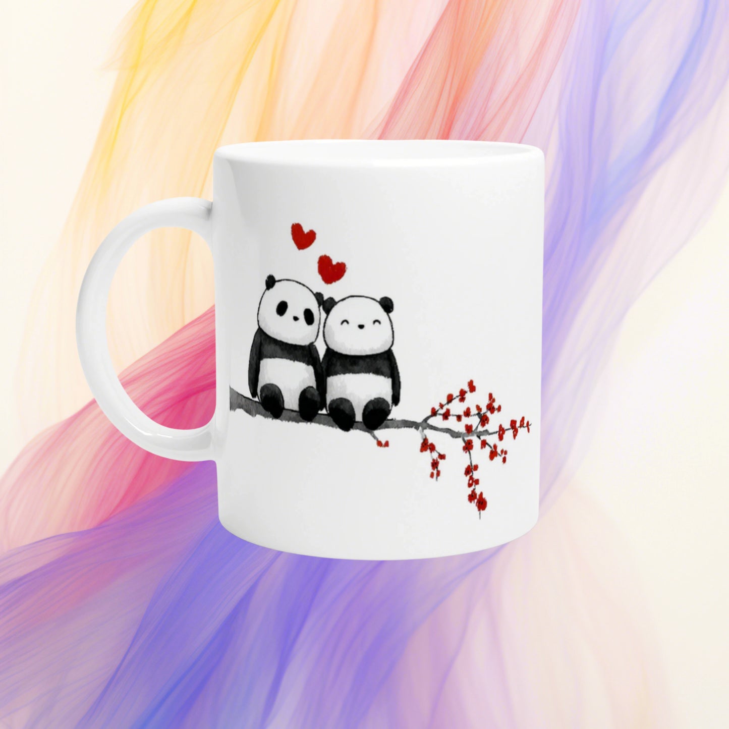 White ceramic mug featuring two pandas on a branch with red hearts above and red blossoms on the branch.