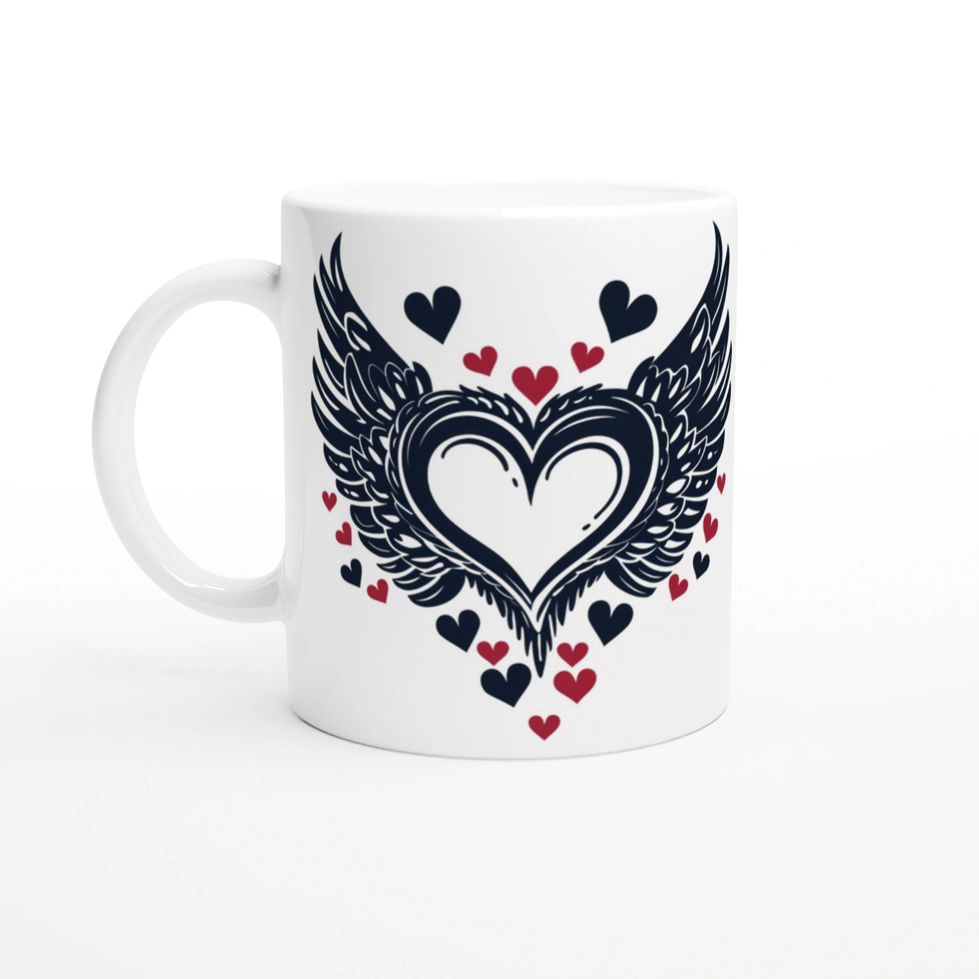 White ceramic mug with a large dark winged heart design, flanked by black and red small hearts.