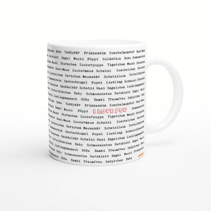 White ceramic mug with an all-over print of black German words; a red 'I LOVE YOU' stands out in the center.