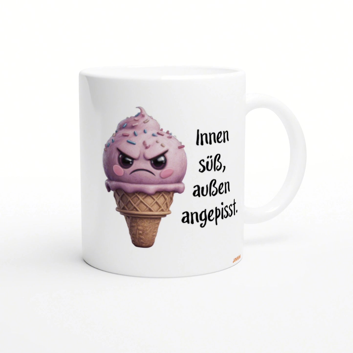 White mug featuring a pink, angry ice-cream cone with sprinkles, alongside the German text Innen süß, außen angepisst.