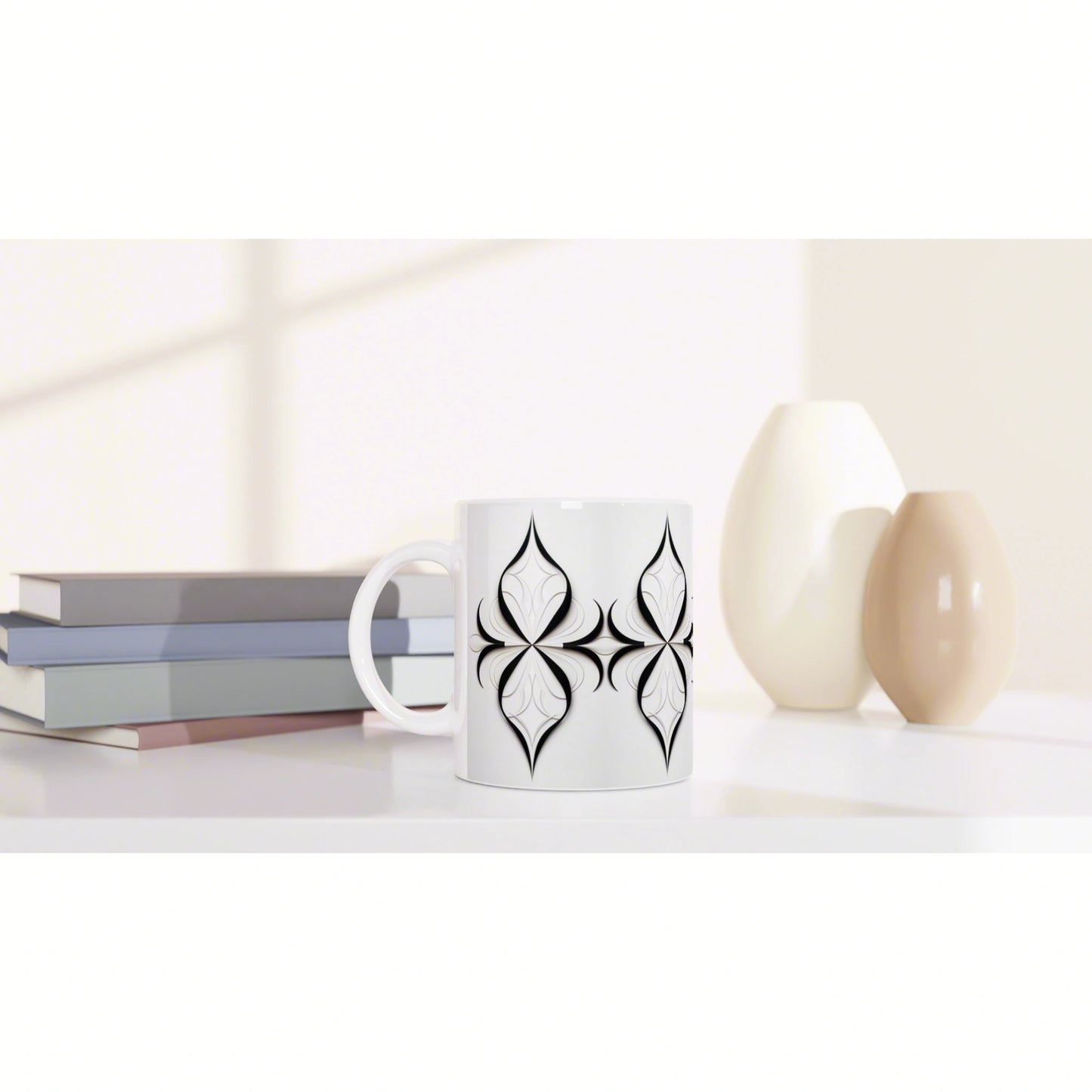 White mug with black geometric pattern on a shelf beside stacked books and beige vases in a bright, minimalist setting.