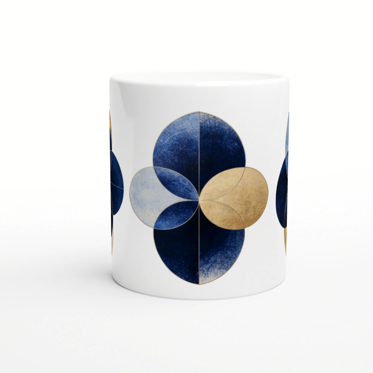 White mug featuring a blue and gold geometric flower motif made from overlapping circular petals; product mockup.