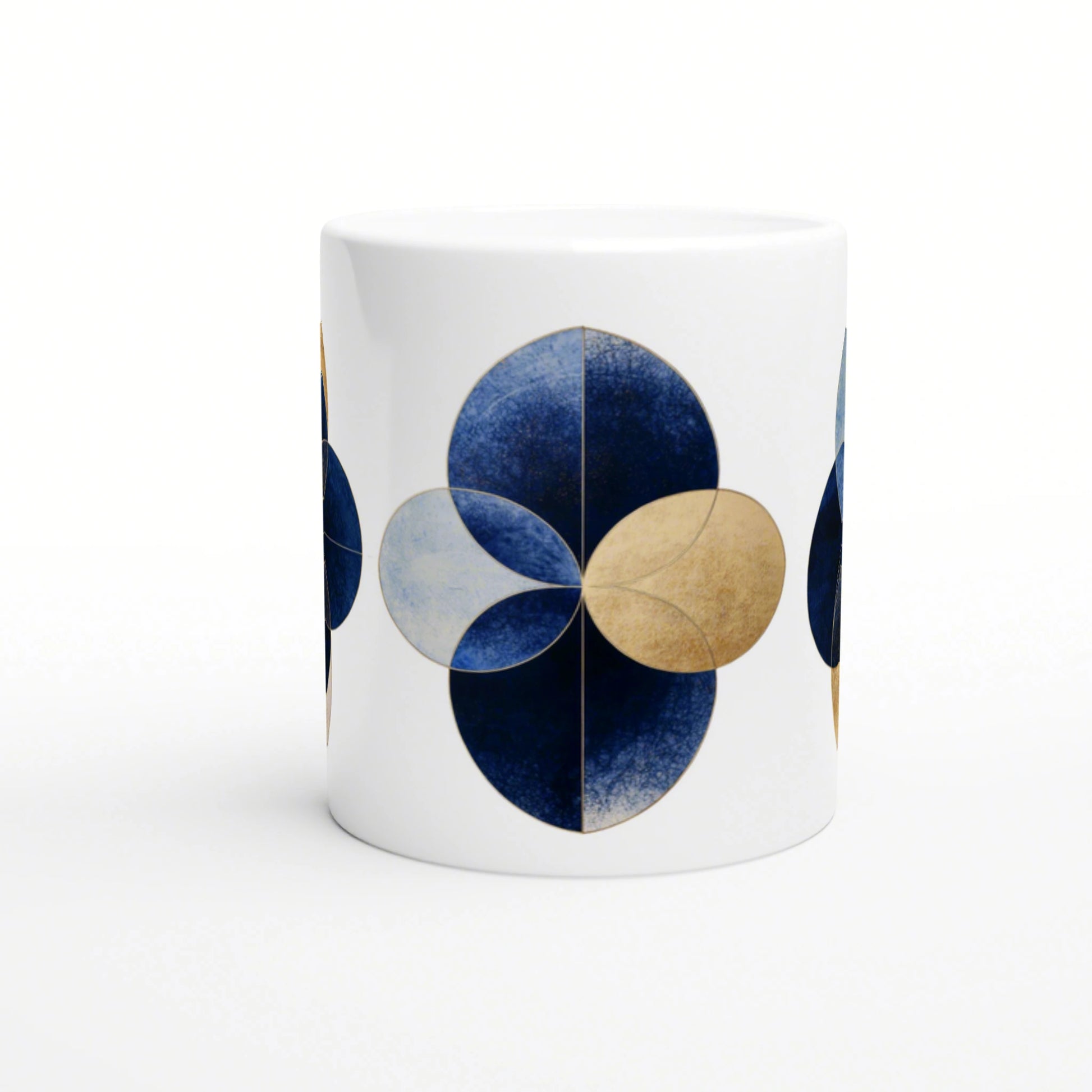 White mug featuring a blue and gold geometric flower motif made from overlapping circular petals; product mockup.