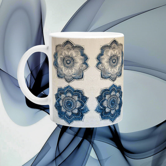 White ceramic mug with four blue mandala floral patterns on beige background; product mockup against an abstract blue backdrop.