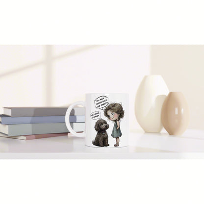 White mug with a cartoon girl and dog in speech bubbles, on a shelf with books and beige vases in a bright, minimal scene.