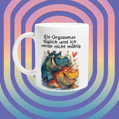White mug with a cartoon of hippos and hearts and a German humorous slogan about orgasms, set against a pastel spiral background.