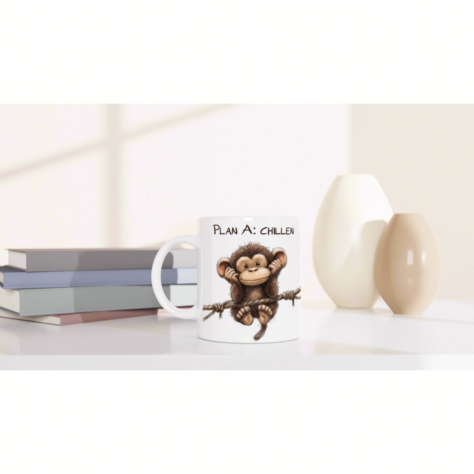 White mug with a cartoon monkey hanging from a rope and the text Plan A: CHILLEN, shown as a product mockup beside books.