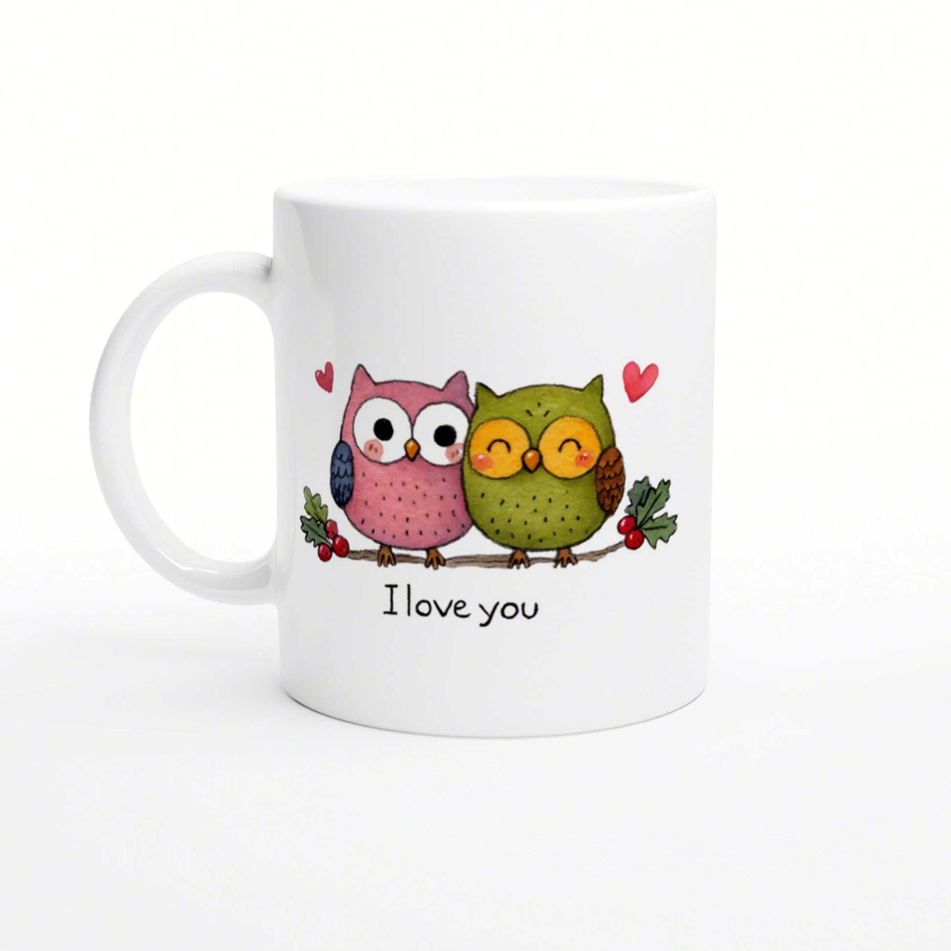 White mug with a cartoon pink and green pair of owls on a branch, with hearts and the text 'I love you'.