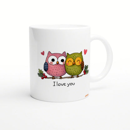White mug with two cute cartoon owls perched on a branch, small hearts, and the phrase I love you.