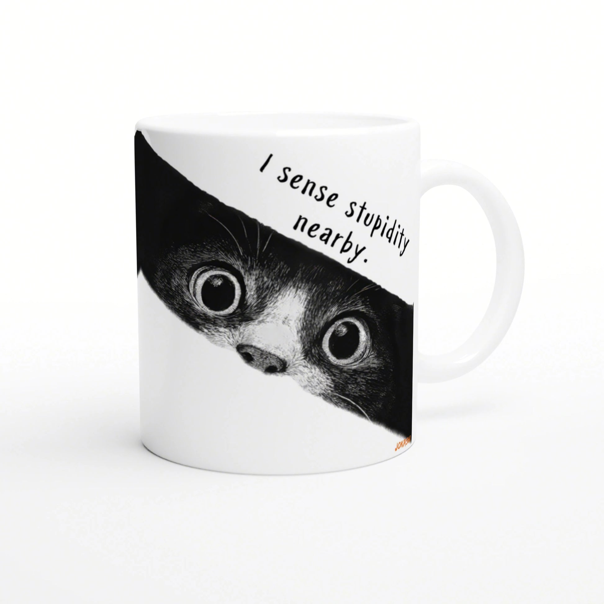 White ceramic mug with a black-and-white cat peeking from the edge and the caption 'I sense stupidity nearby'.
