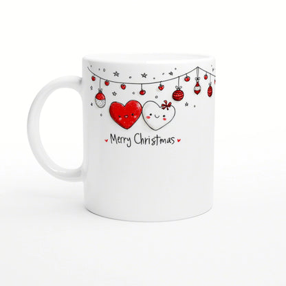White mug with Christmas design: two smiling hearts, hanging ornaments, and 'Merry Christmas' text.